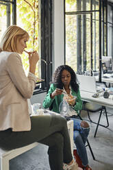 Businesswomen having lunch break in office - ZEDF02798