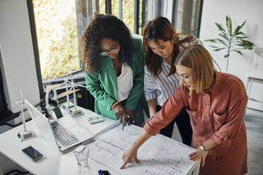 Geschäftsfrauen bei einer Besprechung im Büro mit Windradmodellen auf dem Tisch - ZEDF02839