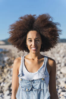 Porträt einer jungen Frau am Strand, die in die Kamera schaut - AFVF04301