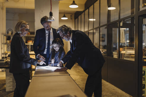 Business people and girl looking at shining tablet in office - GUSF02736