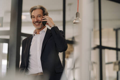 Smiling senior businessman on the phone in office stock photo