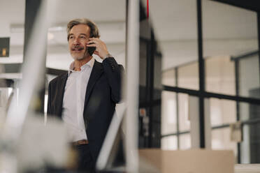 Älterer Geschäftsmann am Telefon im Büro - GUSF02823