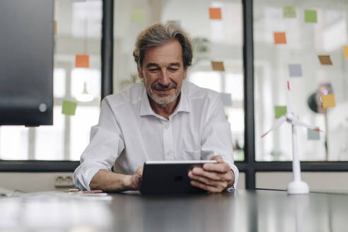 Senior businessman using tablet in conference room in office - GUSF02852