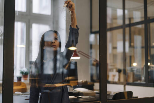 Grl drawing on glass pane in office - GUSF02876