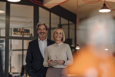 Portait of smiling businessman and businesswoman in office stock photo