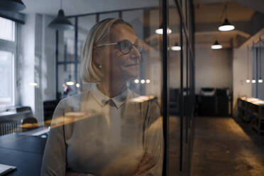 Reife Geschäftsfrau hinter Glasscheibe im Büro - GUSF02935