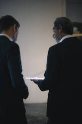 Two businesssmen with shining tablet talking in office - GUSF02944
