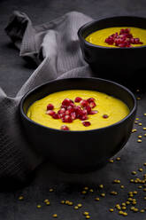 Bowls of vegan lentil soup with ginger, turmeric, coconut milk and pomegranate seeds - LVF08436