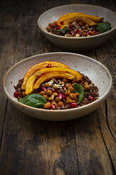 Bowls of quinoa with baked pumpkin, chick-peas, pomegranate, basil, walnuts and pumpkin seeds - LVF08444