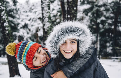 Portrait of happy young couple in winter forest - OCMF00931