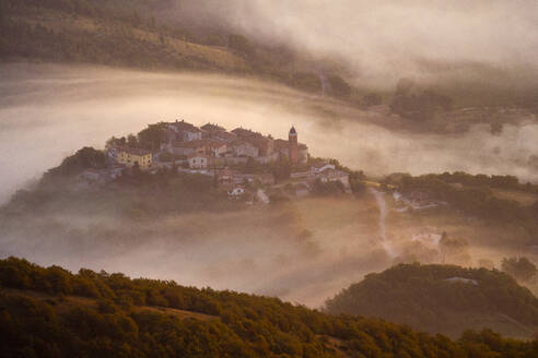 Italien, Luftaufnahme von dichtem Morgennebel, der ein Dorf im Apennin einhüllt - LOMF00931