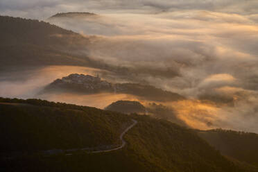 Italien, Luftaufnahme eines dichten Morgennebels, der ein bewaldetes Tal im Apennin einhüllt - LOMF00933
