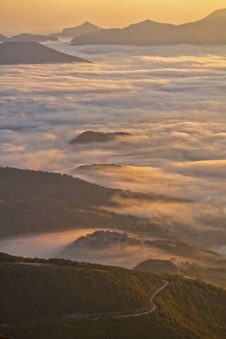 Italien, Luftaufnahme eines dichten Morgennebels, der ein bewaldetes Tal im Apennin einhüllt, lizenzfreies Stockfoto