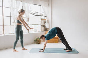 Yogalehrer unterrichtet Yoga im Studio - ISF22959