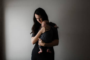Junge Frau, die ihren kleinen Sohn in den Armen trägt, unauffällig - ISF22996