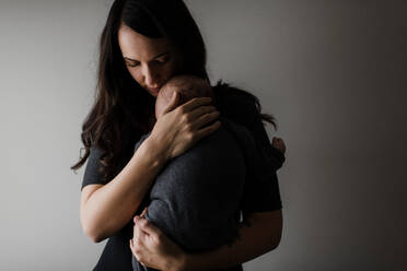Junge Frau wiegt ihren kleinen Sohn in den Armen, unauffällig - ISF22997