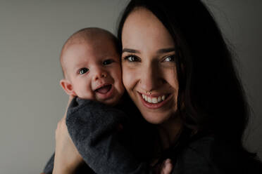 Junge Frau hält ihren kleinen Sohn im Arm, Kopf- und Schulterporträt - ISF23000