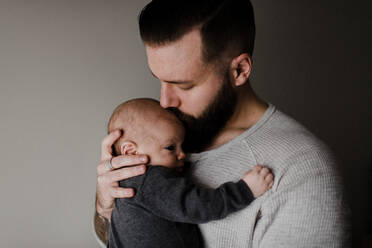 Junger Mann küsst Baby-Sohn auf Kopf, Kopf und Schultern - ISF23005