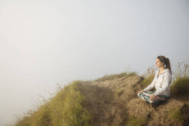 Junge Frau übt Yoga auf einem nebligen Berg, Bali, Indonesien - ISF23074