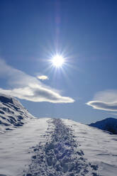 Germany, Bavaria, Wendelstein, Sun shining over footprints in heavy snow - LBF02801