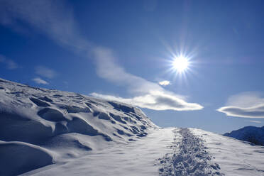Germany, Bavaria, Wendelstein, Sun shining over footprints in heavy snow - LBF02802