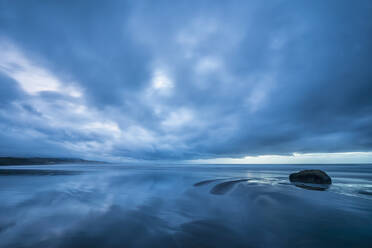 Neuseeland, Tongaporutu, Bewölkter Himmel über sandigem Küstenstrand in blauer Abenddämmerung - FOF11207