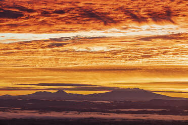 New Zealand, Dramatic sunrise over Tongariro National Park with silhouettes of volcanoes in distance - FOF11221