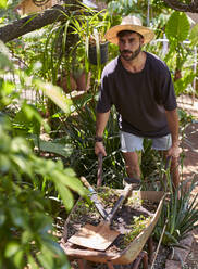 Mann mit einer Schubkarre im Garten - VEGF00879