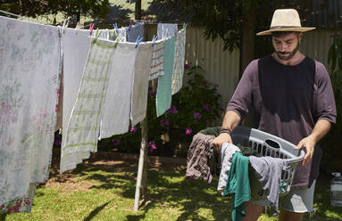Mann hängt Wäsche im Freien auf - VEGF00881