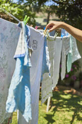 Man hanging up laundry outdoors - VEGF00896