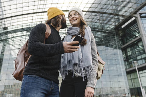 Junges Paar benutzt ein Smartphone am Hauptbahnhof, Berlin, Deutschland, lizenzfreies Stockfoto