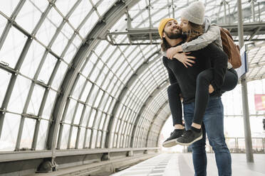 Happy young couple having fun and kissing at the station platform, Berlin, Germany - AHSF01433