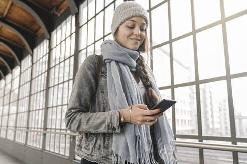 Young woman using smartphone at the station platform, Berlin, Germany - AHSF01441