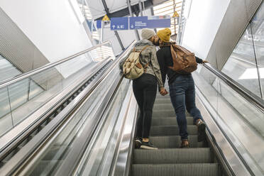 Junges Paar, das sich auf einer Rolltreppe am Bahnhof küsst, Berlin, Deutschland - AHSF01447