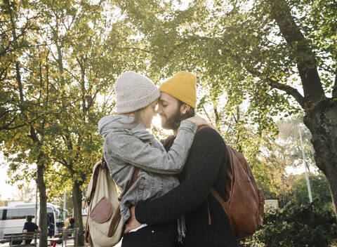 Junges Paar umarmt sich in einem Stadtpark, Berlin, Deutschland, lizenzfreies Stockfoto