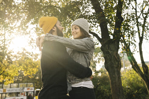 Junges Paar umarmt sich in einem Stadtpark, Berlin, Deutschland - AHSF01465