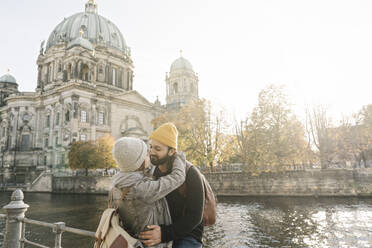 Young couple embracing with Berlin Cathedral in background, Berlin, Germany - AHSF01468