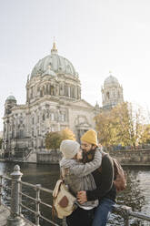 Young couple embracing with Berlin Cathedral in background, Berlin, Germany - AHSF01469