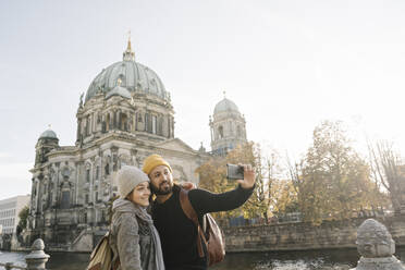 Junges Paar macht ein Selfie mit dem Berliner Dom im Hintergrund, Berlin, Deutschland - AHSF01470