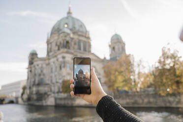 Nahaufnahme eines Mannes, der ein Smartphone-Foto vom Berliner Dom macht, Berlin, Deutschland - AHSF01472