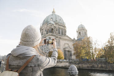 Young woman taking a smartphone picture of Berlin Cathedral, Berlin, Germany - AHSF01473