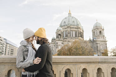 Junges Paar in Umarmung mit dem Berliner Dom im Hintergrund, Berlin, Deutschland - AHSF01474