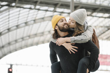 Happy young couple having fun and kissing at the station platform, Berlin, Germany - AHSF01489