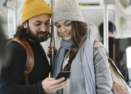 Junges Paar benutzt Smartphone in einer U-Bahn - AHSF01505