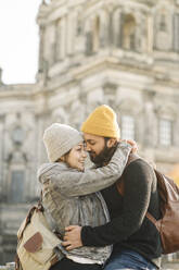 Happy young couple embracing with Berlin Cathedral in background, Berlin, Germany - AHSF01513