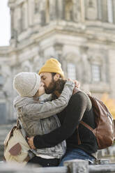 Affectionate young couple kissing with Berlin Cathedral in background, Berlin, Germany - AHSF01514