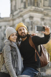 Junges Paar macht ein Selfie mit dem Berliner Dom im Hintergrund, Berlin, Deutschland - AHSF01516