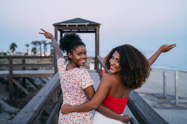 Back view of anonymous female friends in swimwear and summer