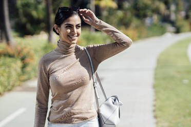 Portrait of smiling young woman on a path - JSMF01373