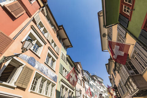Schweiz, Kanton Zürich, Zürich, Schweizer Fahnen hängen über der historischen Augustinergasse, lizenzfreies Stockfoto